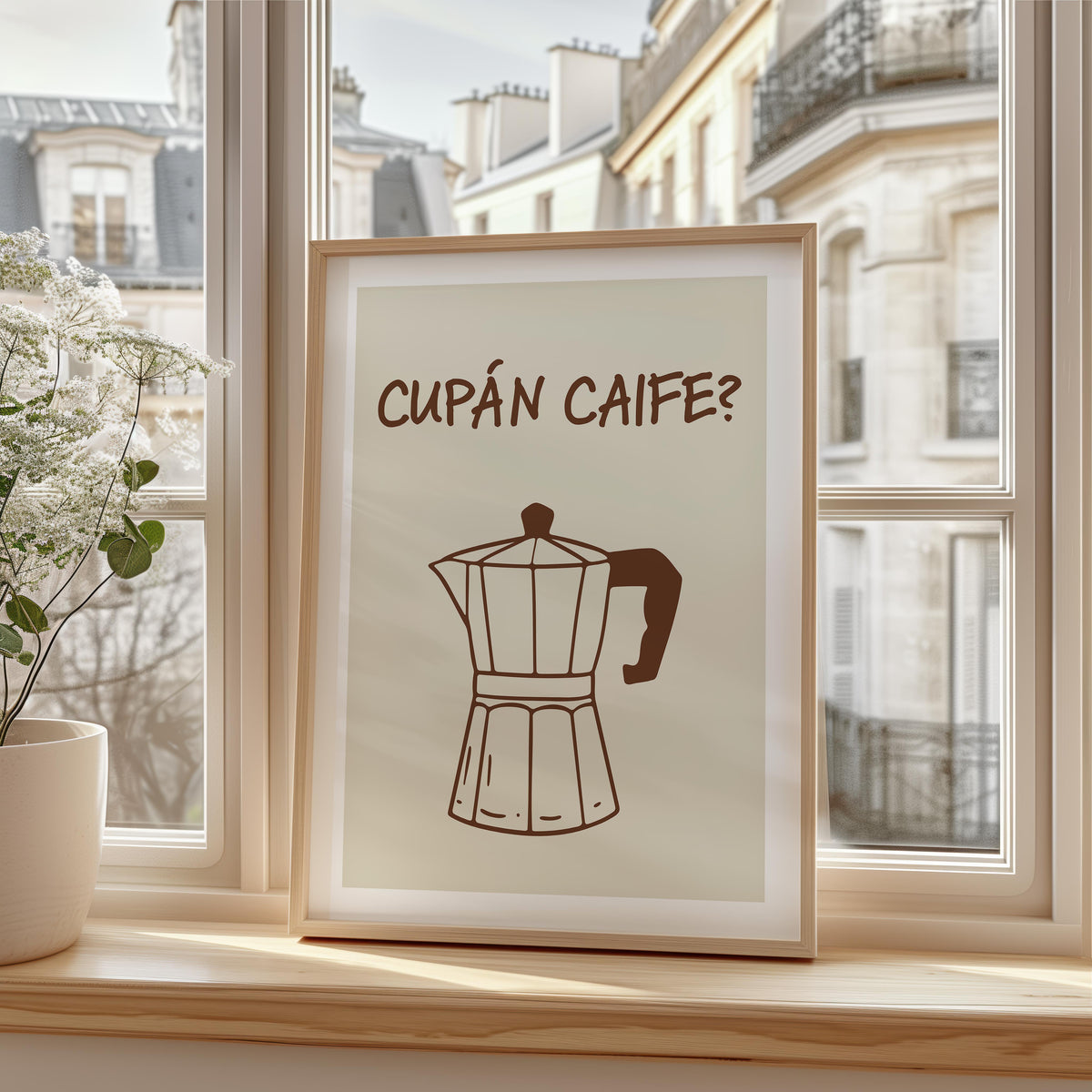 A framed art print with the text 'CUPÁN CAIFE?' and a simple brown coffee pot